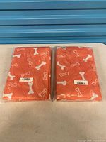 Two sealed orange quilted pet cooling mats side by side