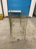 Full view of assembled gold-tone metal wire folding dog crate