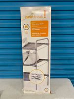 Front of boxed Neatfreak 3-tier shoe shelf showing branding and product image