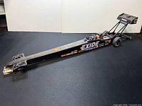 Left side view of entire slot car showing EXIDE graphics and chassis length