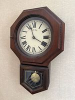 Full view of Bulova wooden wall clock mounted on wall