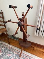 Front view of six-arm wooden yarn winder on tripod base