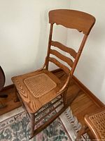 front angled view of wooden ladder back rocking chair