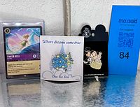 Group shot: both pins on backing cards and Lorcana card with MaxSold placard