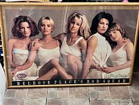 Full view of framed poster showing cast image, frame, and size context