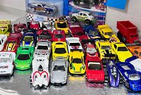 Wide shot of all loose cars in rows, carded BLVD Bruiser and Matchbox DOTS Beetle, additional vehicles at rear
