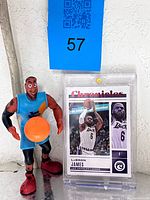 LeBron James action figure next to serial-numbered Panini Chronicles card in case