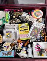Top view of tray showing full assortment including magnets, brochure, jewelry, figurines, and boxed trinkets
