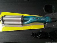Deep wave curling iron in worn retail blister packaging, front view