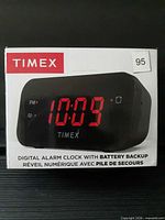 Front of sealed Timex digital alarm clock box showing red LED display