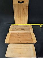 All four cutting boards laid flat with tape for scale