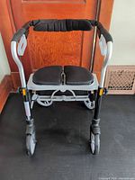 Front view showing padded split seat, handles, wheels