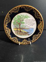 Front view showing cobalt rim, gold filigree, landscape scene and poem text