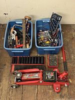 Overview of floor jack, impact sockets and two bins of assorted tools