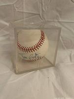 Front view of signed baseball in acrylic cube showing signature