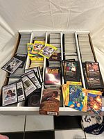 Overall view of four-row box filled with assorted cards including sports and various CCGs