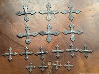 Full lot showing 14 metal cross mounts in size order
