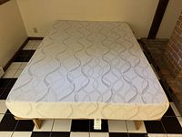 Full view of queen mattress on slat platform frame