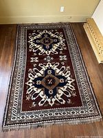 Full view of rectangular Kazak rug on wood floor