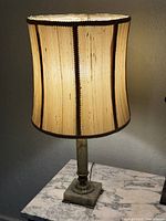 Full view of lamp with shade on marble surface