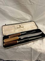 Full view of carving set in open case showing three utensils and interior branding
