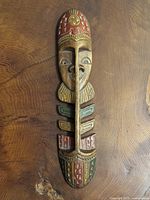 Front view of carved wooden mask showing painted details