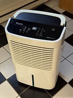 Front view of Whirlpool Gold Series dehumidifier showing air intake grille and water level window