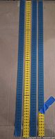 Four 120 cm rulers laid out: three blue, one yellow