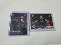 Front view of both Lionel Messi Topps Now cards in sleeves