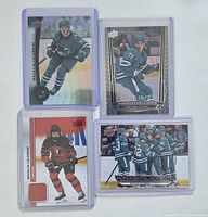 All four Macklin Celebrini hockey cards in sleeves displayed