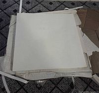 Stack of white square ceramic sheets on packaging