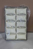 Front view of velvet watch display tray wrapped in plastic showing ten pillow slots