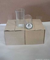 Two clear glass tumblers displayed on unopened cardboard box
