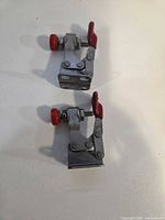 Two small Destaco toggle clamps showing top view with red adjustment knobs