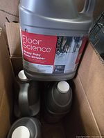 Open carton showing four sealed jugs labeled Floor Science Heavy Duty Floor Stripper