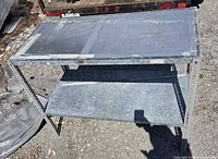 Front angled view of metal work bench showing top and shelf