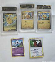 All five cards: three graded Pikachu slabs and two raw cards