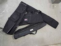 Both black soft travel cases laid out to show size and shape differences