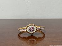 Front view of gold-tone Andre Mouche floral bangle watch