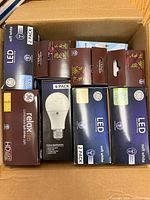 Open box showing nine sealed GE LED bulb retail cartons