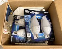 Box containing three GE LED 2-packs and one 25 W incandescent 2-pack