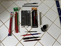Full layout of all pens, pencils, refills, rulers, knife, loupe