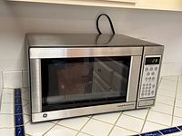 Front view of stainless steel GE microwave showing control panel and door
