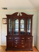 Full view of cherry china cabinet showing upper glass hutch and lower drawer base