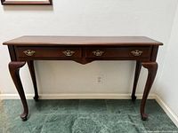 Front view of mahogany console table showing drawers and legs