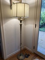 Full view of brass floor lamp with shade