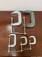 All five C-clamps laid out on table