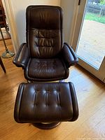 Front view of brown leather Stressless Royal recliner with ottoman