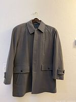 Full front view of grey Eric Ross overcoat on hanger