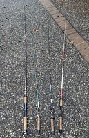 Four fishing rods laid side by side displaying full length